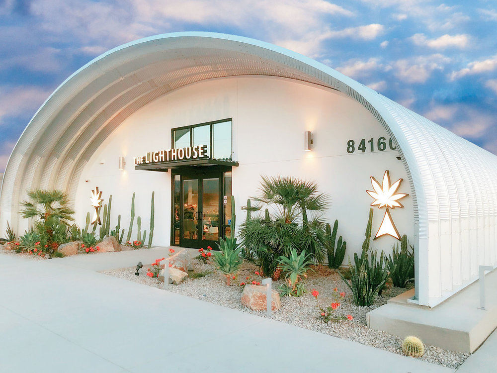 Custom white end wall on S-Model Quonset hut with The Lighthouse sign in front