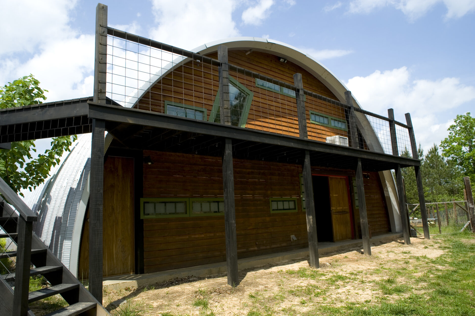 Q-Model building with custom end wall, custom windows with olive green trim and a black balcony