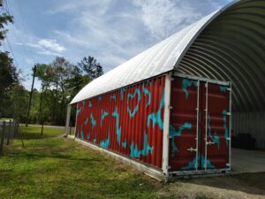 steel arch roof mounted on multicolor red and blue shipping container