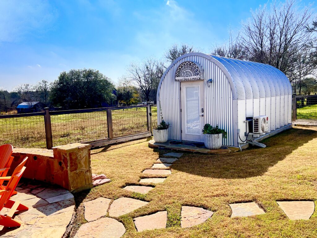 steel S model storage shed with custom metal front endwall and white walk through door and pavers in front